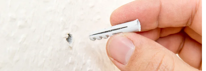 Hand hält einen Dübel